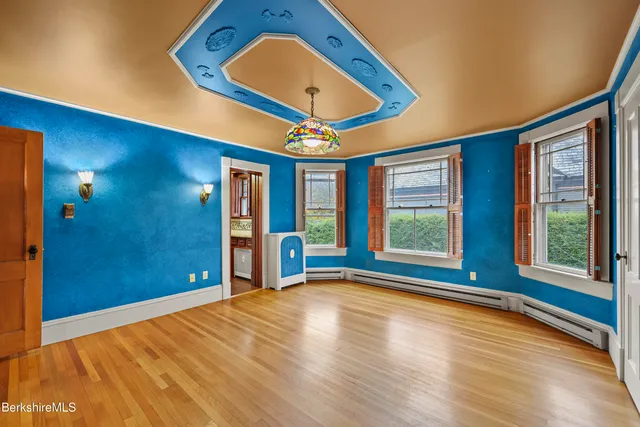 a view of a room with window wooden floor and front door