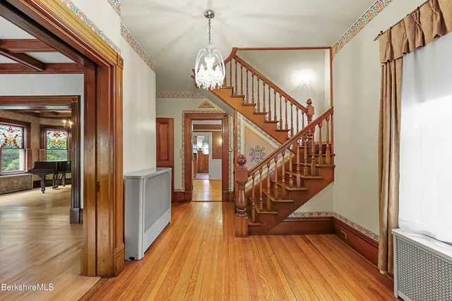 a view of entryway and hall with wooden floor