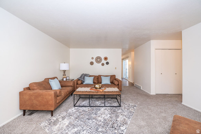 621 Coachman Way Riverdale, UT 84405 - Photo 16 of 38 Living area featuring light carpet and baseboards