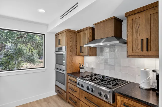 a kitchen with granite countertop a stove and a refrigerator