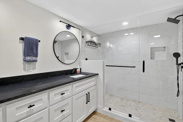 a bathroom with a double vanity sink mirror and shower