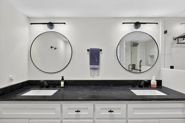 a bathroom with a granite countertop sink and a mirror