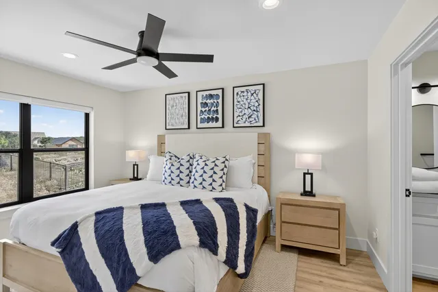 a bedroom with a bed a lamp and a large window