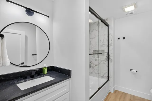 a bathroom with a sink a mirror and a shower