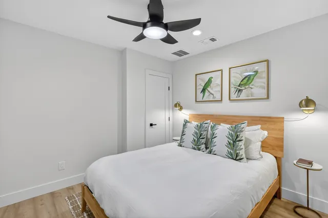 a bedroom with a bed and a painting on the wall