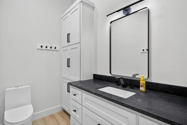 a bathroom with a granite countertop sink and a mirror