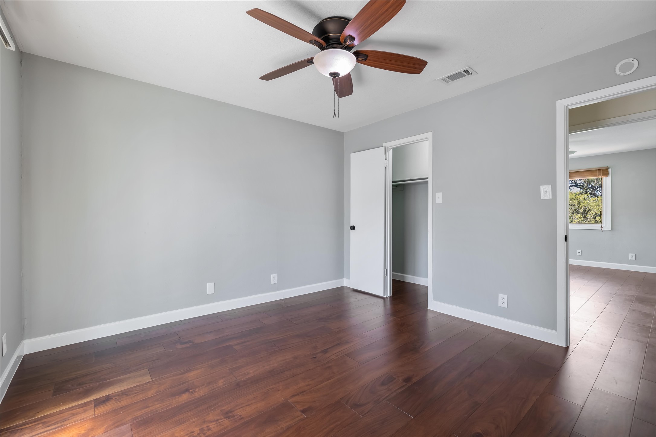 1703 Waterloo Trail, Unit B Austin, TX 78704 - Photo 23 of 36 Unfurnished bedroom with dark wood-style flooring, a ceiling fan, and a closet