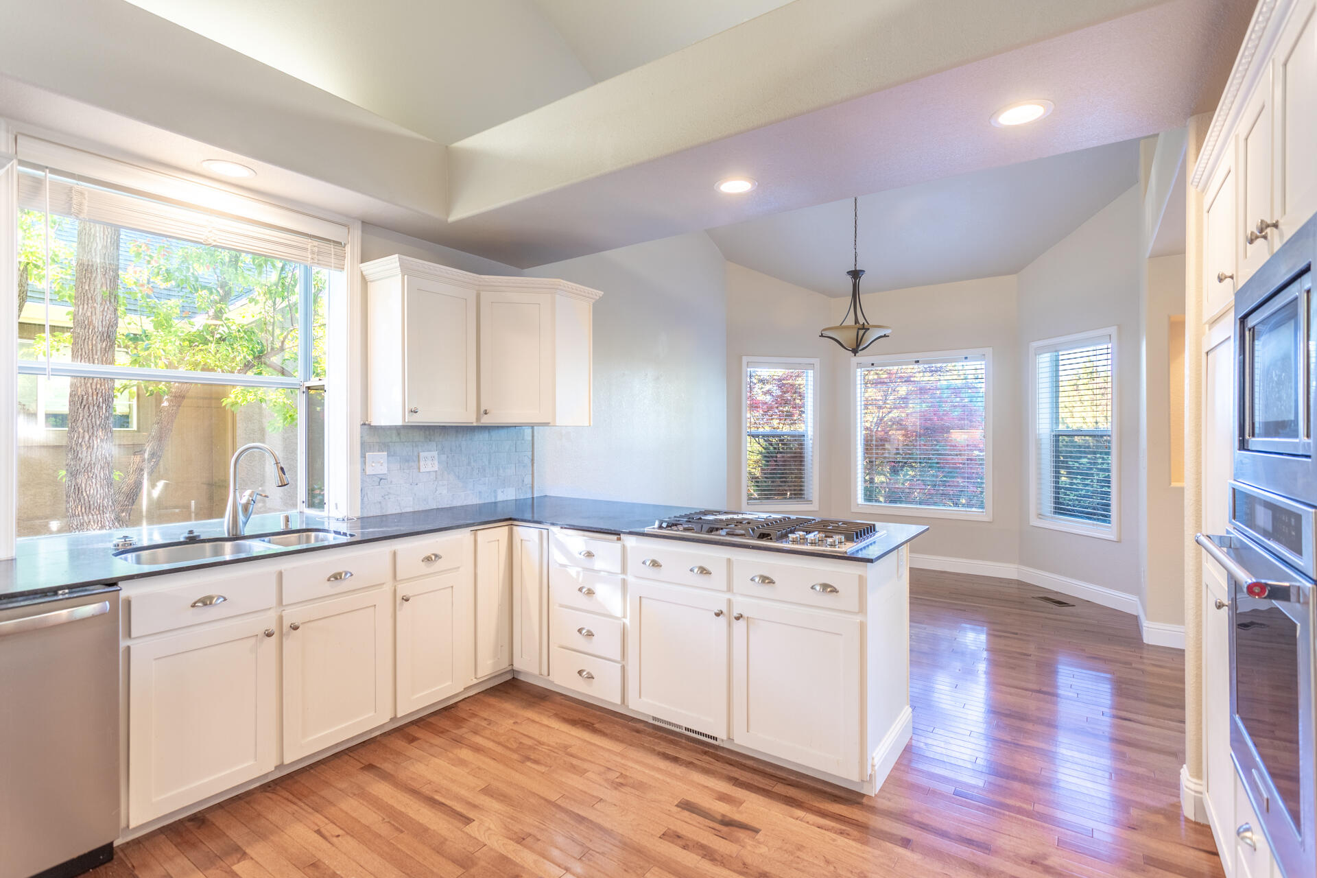 3126 Riesling Path Redding, CA 96001 - Photo 9 of 32 a kitchen with granite countertop white cabinets and white appliances
