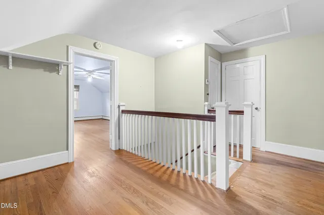 a view of a hallway with entryway and wooden floor