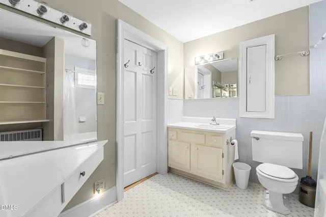 an empty room with wooden floor closet and windows