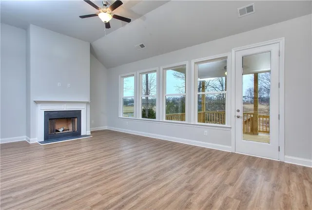 wooden floor fireplace and windows in an empty room