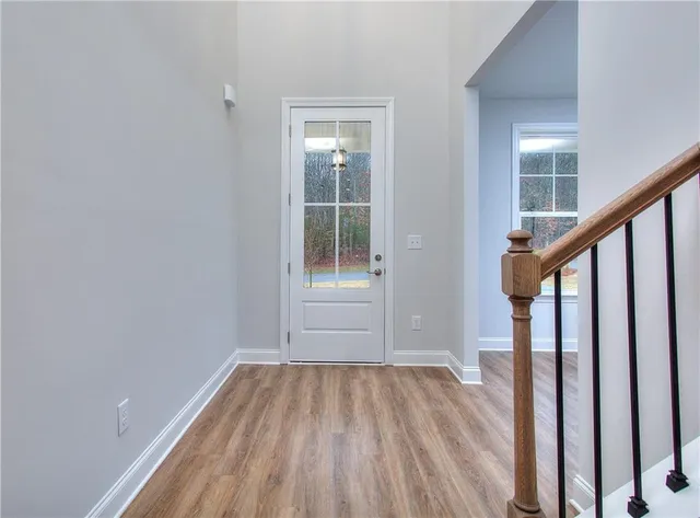 a view of an empty room with wooden floor and stairs