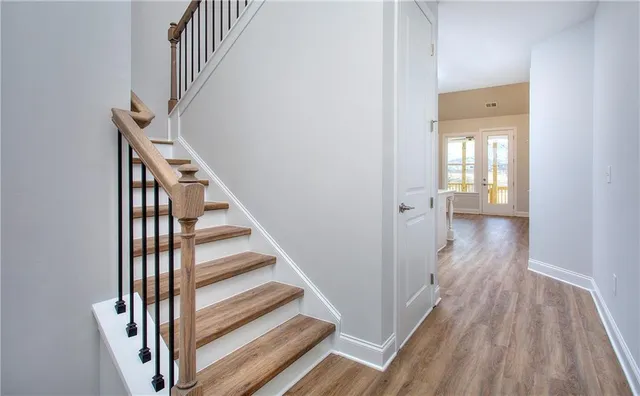 a view of a hallway with wooden floor and entryway