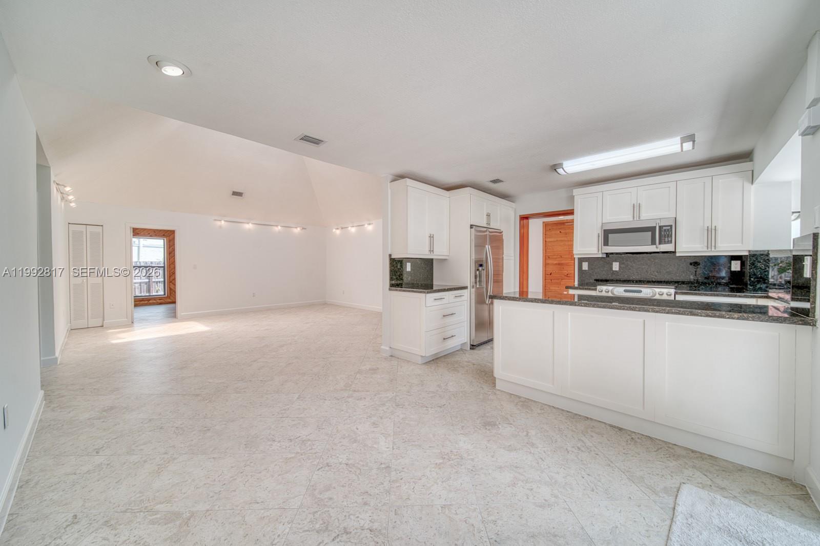 a view of a kitchen with a sink and cabinets