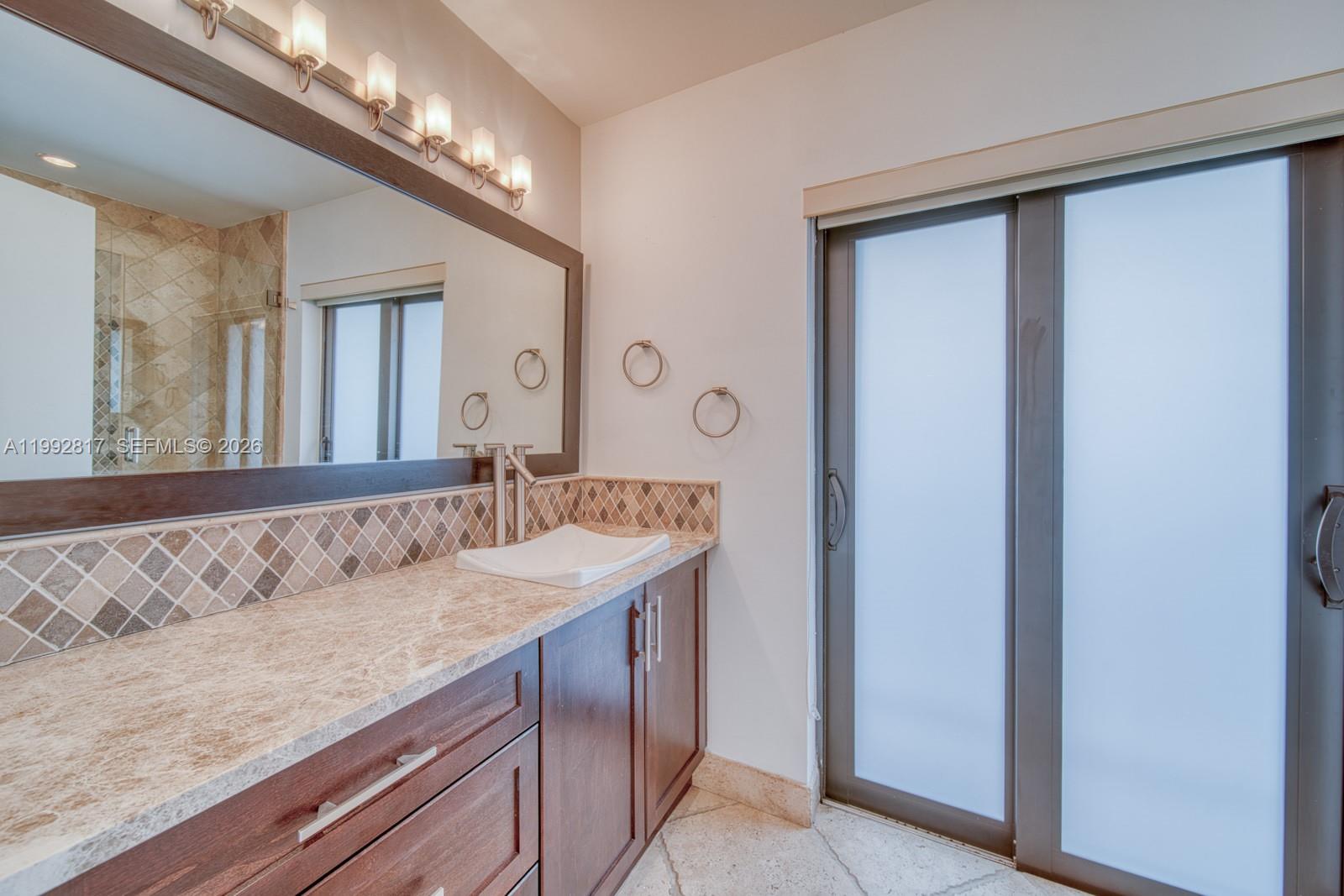 7320 Southwest 100th Court Miami, FL 33173 - Photo 16 of 36 a bathroom with a granite countertop sink and a mirror