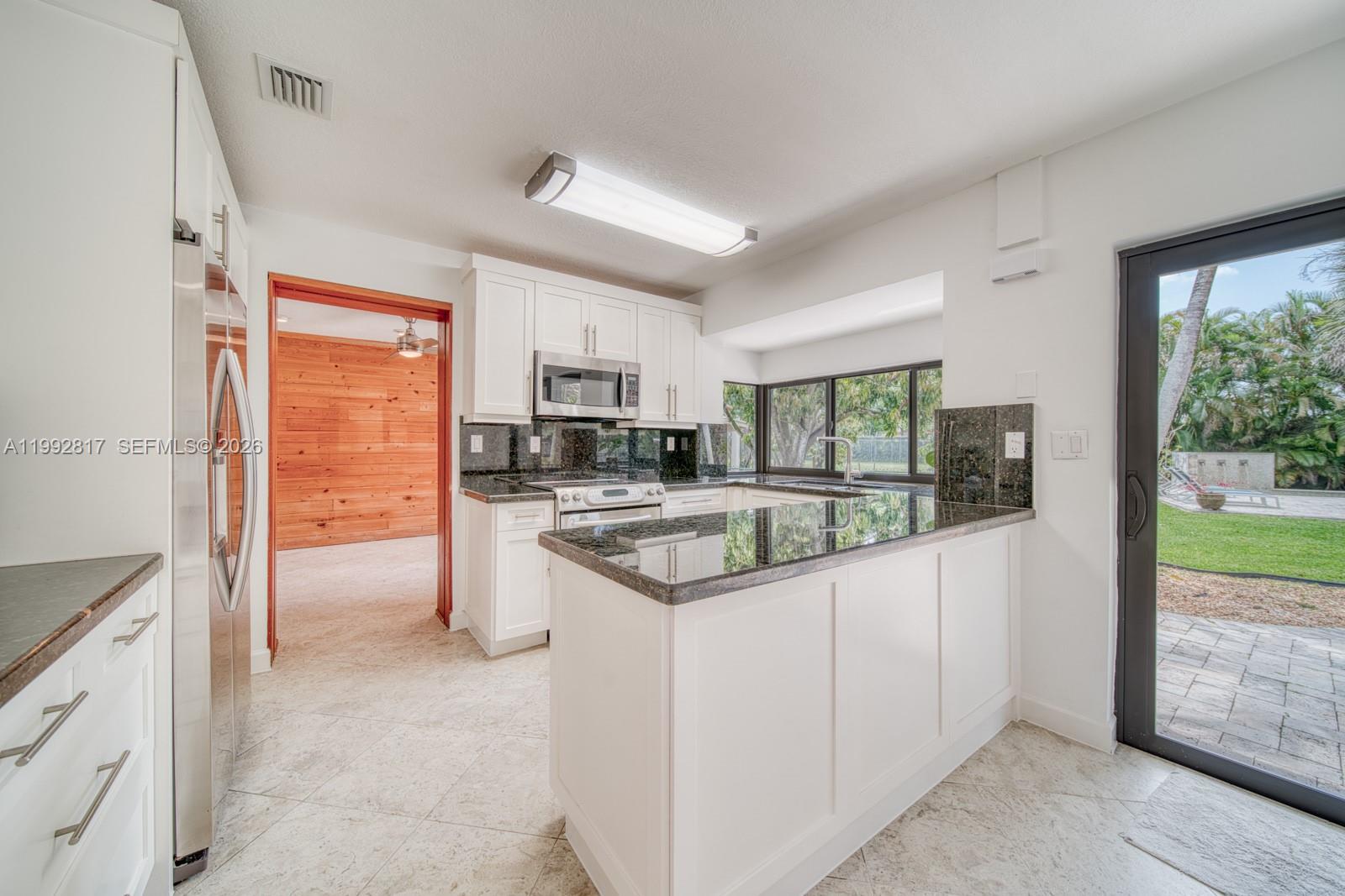 7320 Southwest 100th Court Miami, FL 33173 - Photo 8 of 36 a kitchen with stainless steel appliances granite countertop a stove a sink and a refrigerator