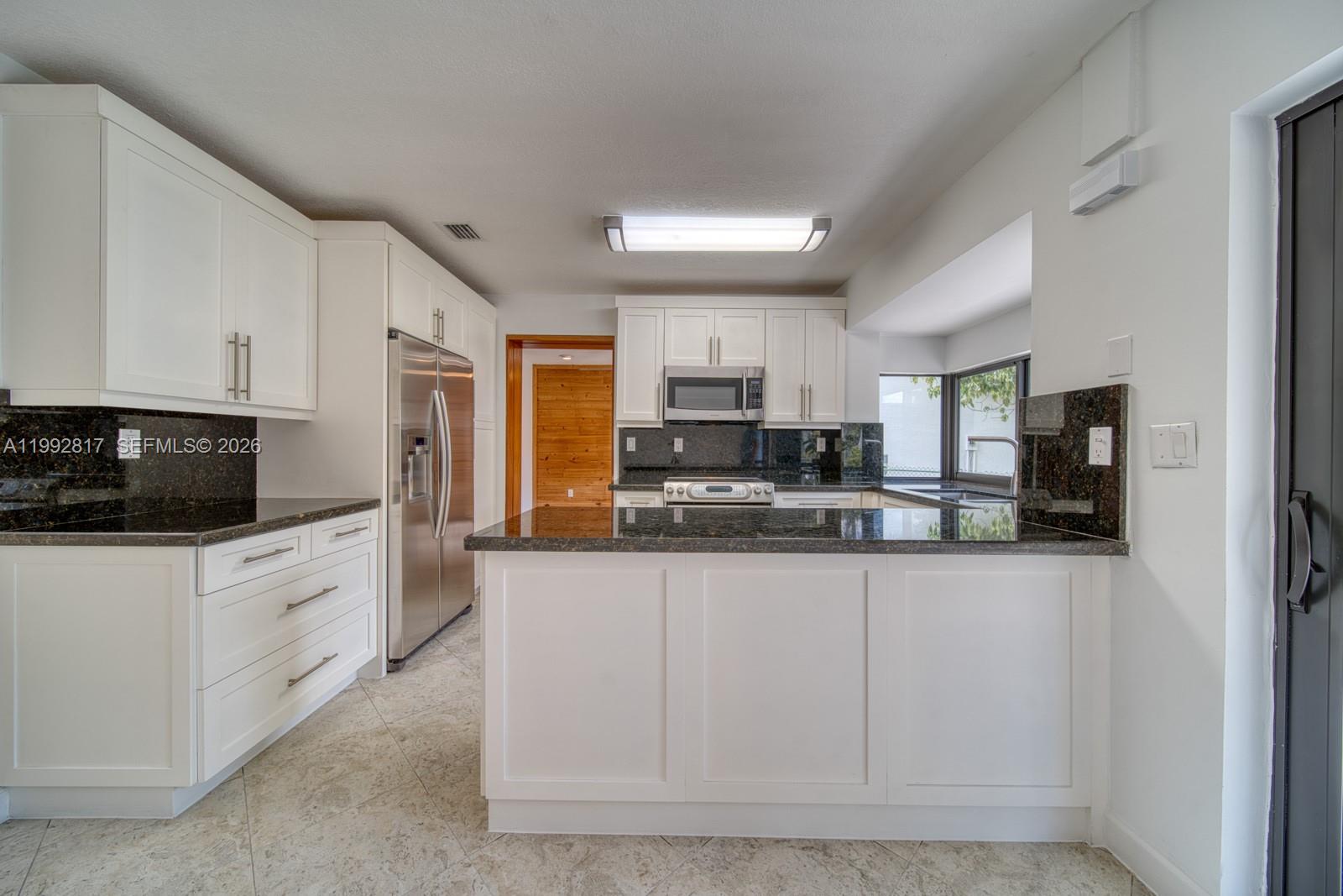 7320 Southwest 100th Court Miami, FL 33173 - Photo 9 of 36 a kitchen with granite countertop white cabinets and stainless steel appliances