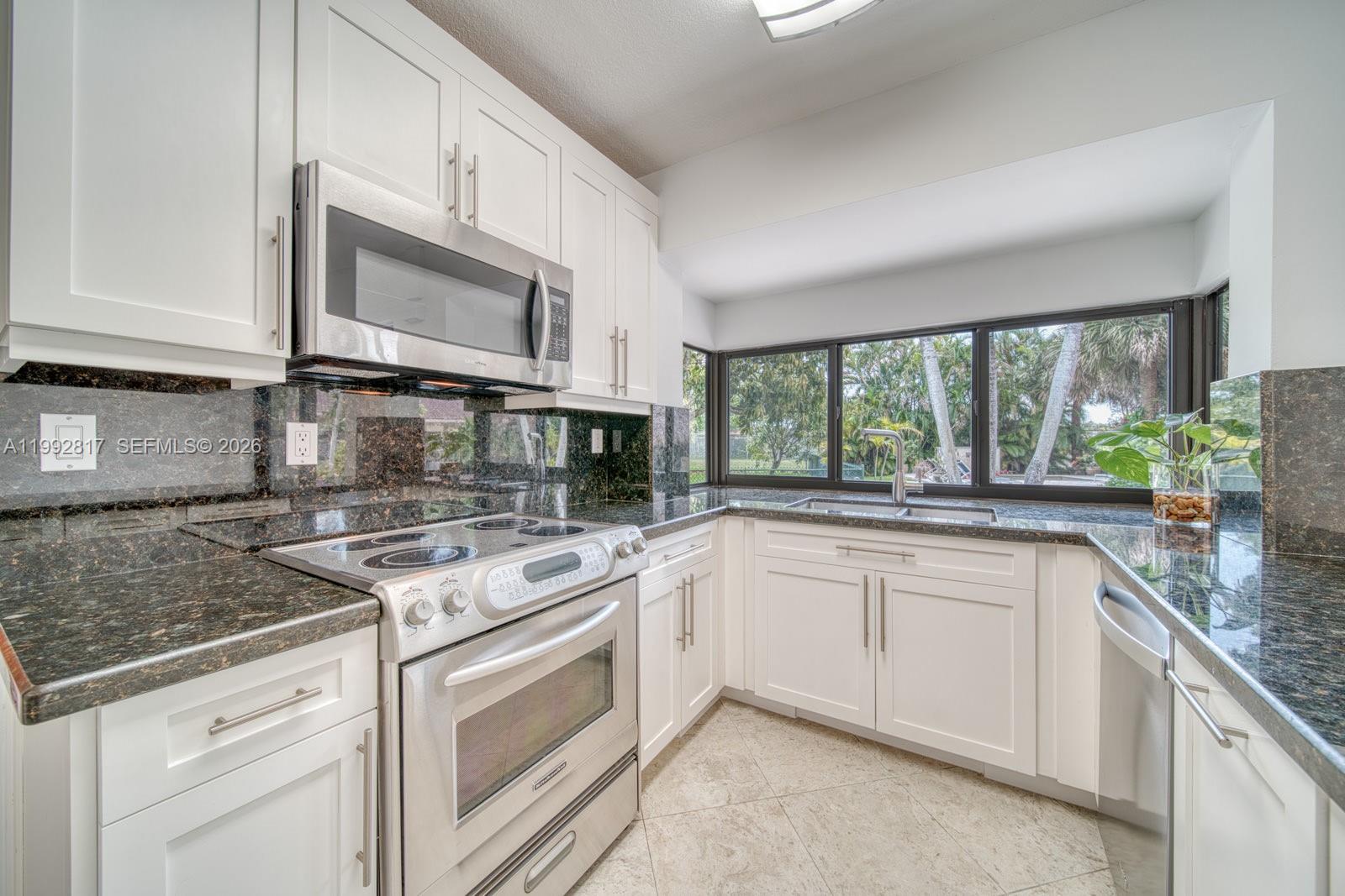 7320 Southwest 100th Court Miami, FL 33173 - Photo 10 of 36 a kitchen with stainless steel appliances granite countertop a sink and cabinets