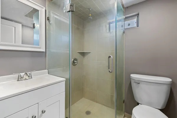 a bathroom with a toilet sink shower and a mirror