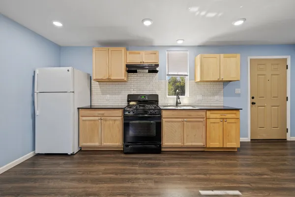 a kitchen with a sink a stove top oven and cabinets
