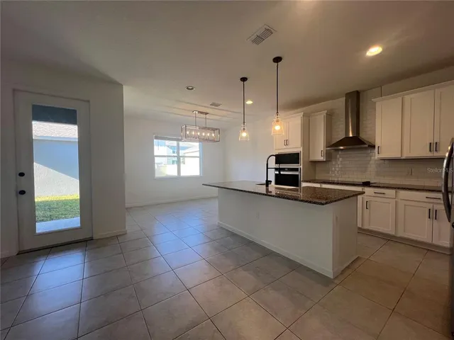 a kitchen with stainless steel appliances granite countertop a sink a stove a microwave a counter top and cabinets