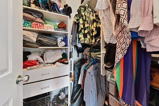 a view of walk in closet with clothes and shoes