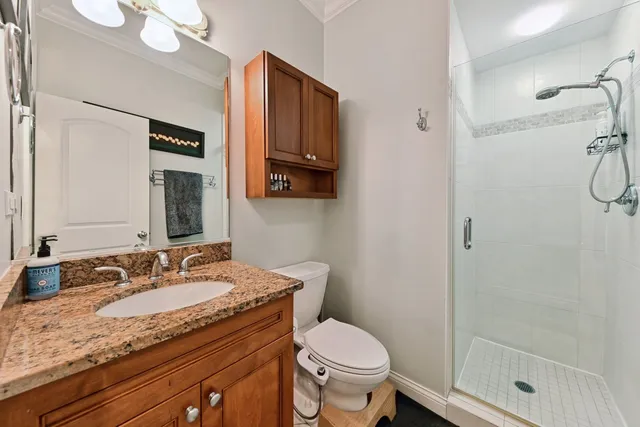 a bathroom with a granite countertop sink toilet and shower