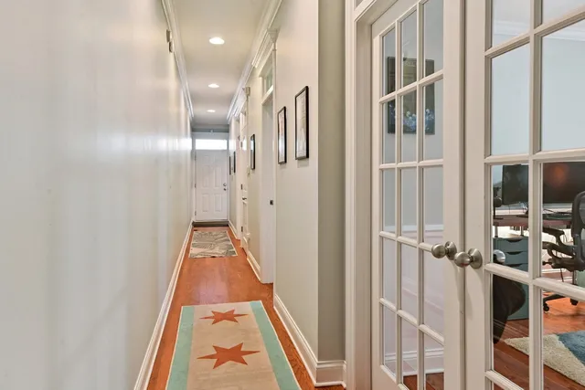 a view of a hallway with wooden floor and staircase