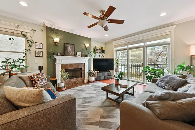 a living room with furniture fireplace and a large window