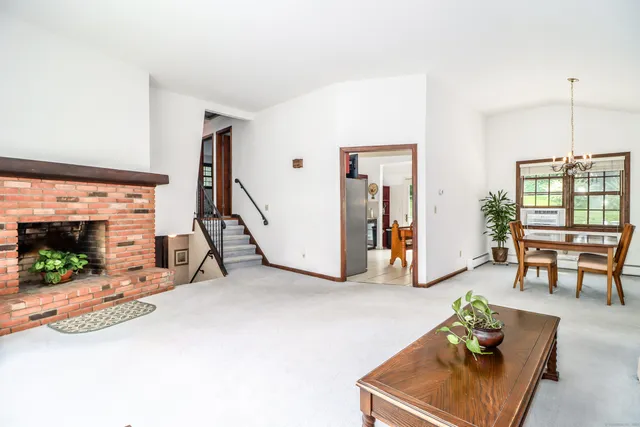 a dining room with furniture potted plants and a chandelier