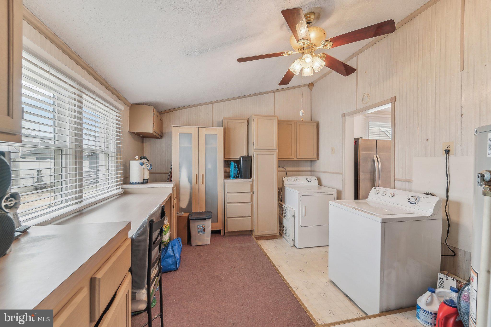8218 Longpoint Road Dundalk, MD 21222 - Photo 13 of 30 a large white kitchen with a sink a refrigerator and a large window