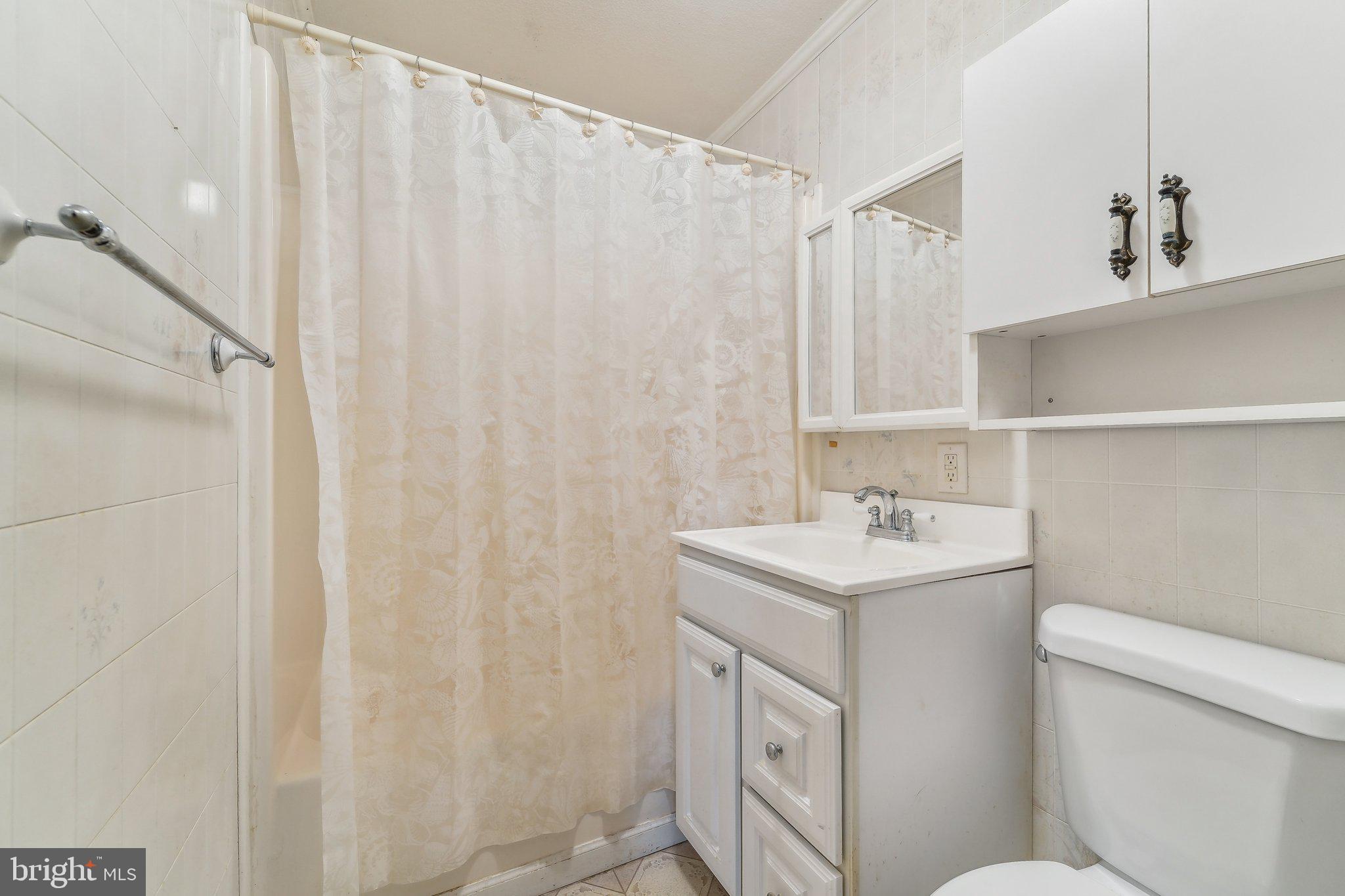 8218 Longpoint Road Dundalk, MD 21222 - Photo 19 of 30 a bathroom with a sink a toilet and a mirror