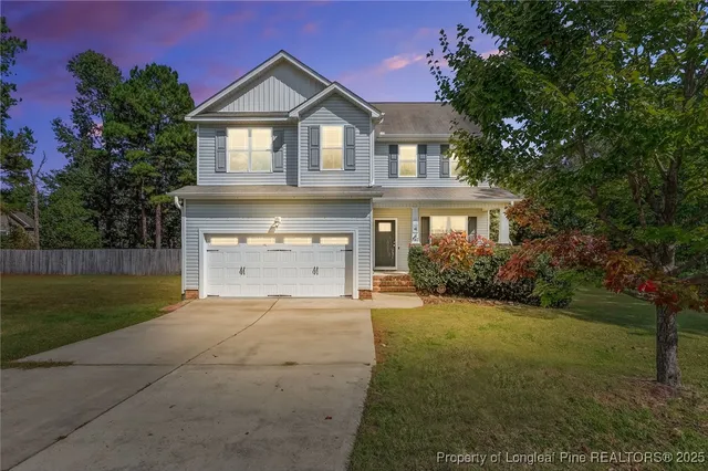a front view of a house with a yard and garage