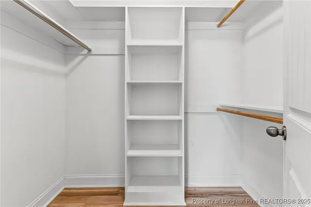 a view of walk in closet with empty racks