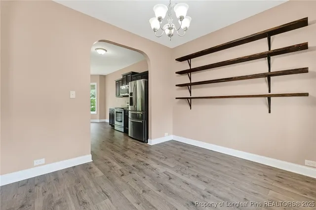 a view of a big room with wooden floor and windows