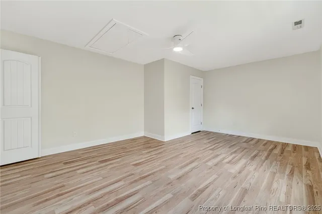 a view of empty room with wooden floor