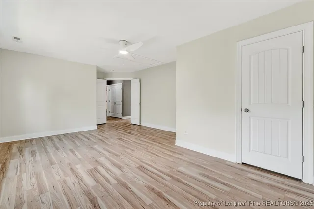 a view of an empty room with wooden floor