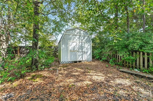 a backyard of a house with large trees and outdoor seating
