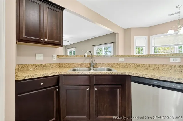 a kitchen with granite countertop a sink and a wooden cabinets