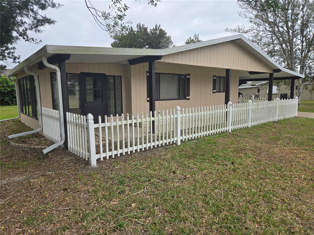 10040 Southwest 98th Avenue Ocala, FL 34481 - Photo 3 of 28 a white house that has a small yard and large trees