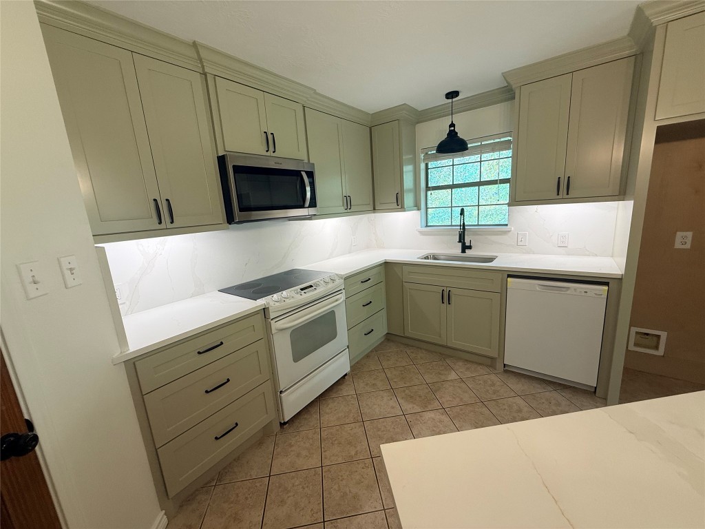 855 County Road 2267 Cleveland, TX 77327 - Photo 19 of 24 a kitchen with stainless steel appliances a sink a stove a microwave a sink a refrigerator and cabinets