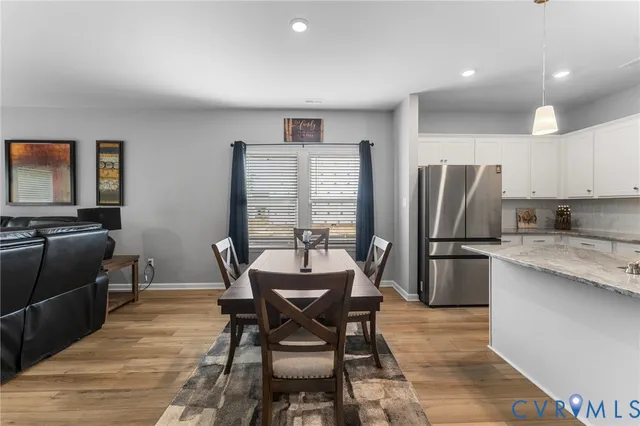 a view of a dining room with furniture and a refrigerator