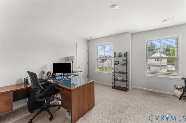 a view of a workspace with furniture and a window