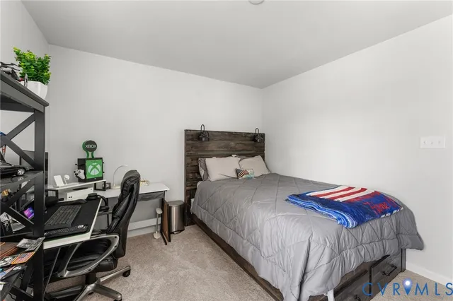 a bedroom with a bed a chair and a potted plant on the table
