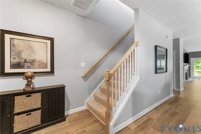 a view of a hallway with wooden floor and stairs