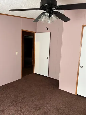 an empty room with a ceiling fan and wooden floor