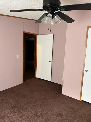 an empty room with a ceiling fan and wooden floor