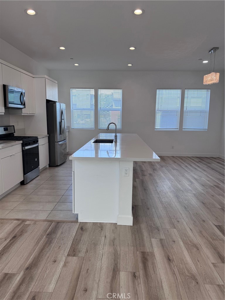 438 Hudson Street Brea, CA 92821 - Photo 11 of 29 a large kitchen with stainless steel appliances a large counter top and wooden floors