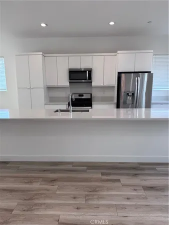 a kitchen with stainless steel appliances cabinets and wooden floor