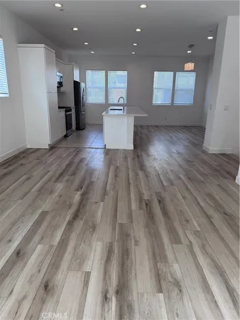 a view of a living room hardwood floor and a kitchen counter space